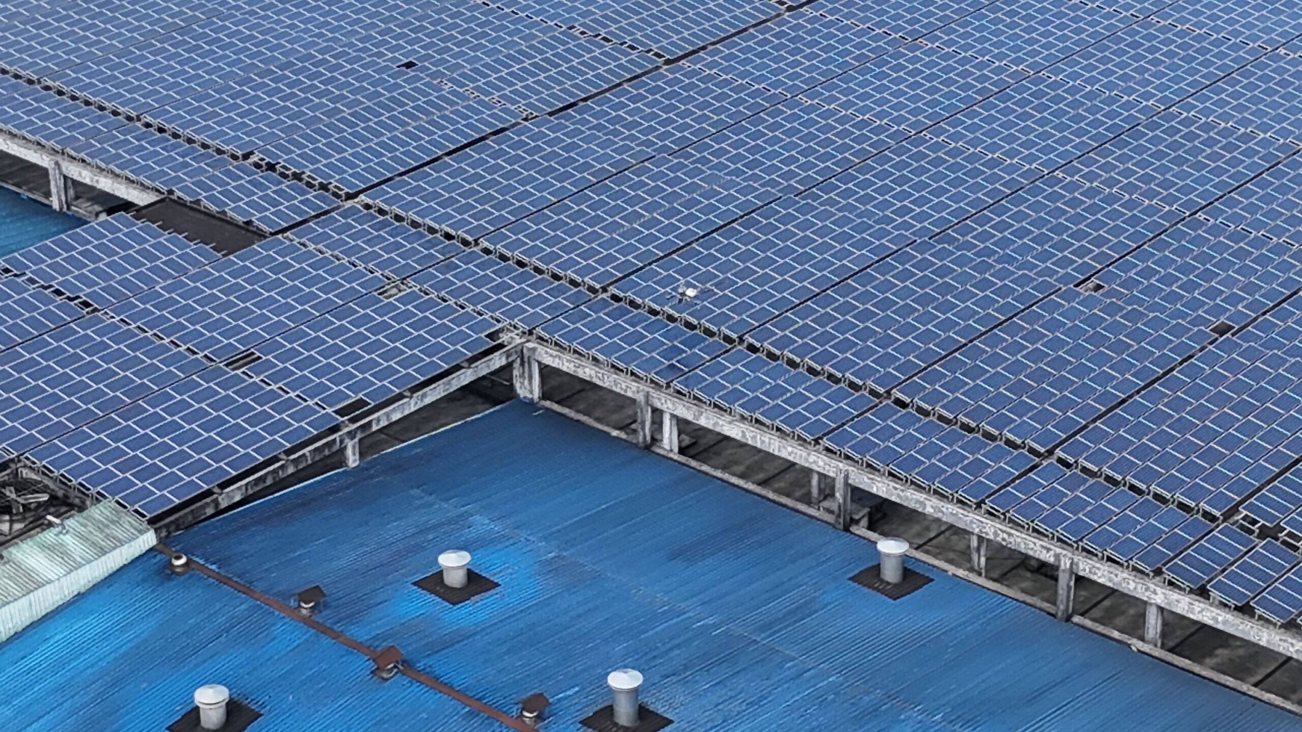 Große Industriehalle mit vollflächiger Photovoltaikanlage auf dem Dach