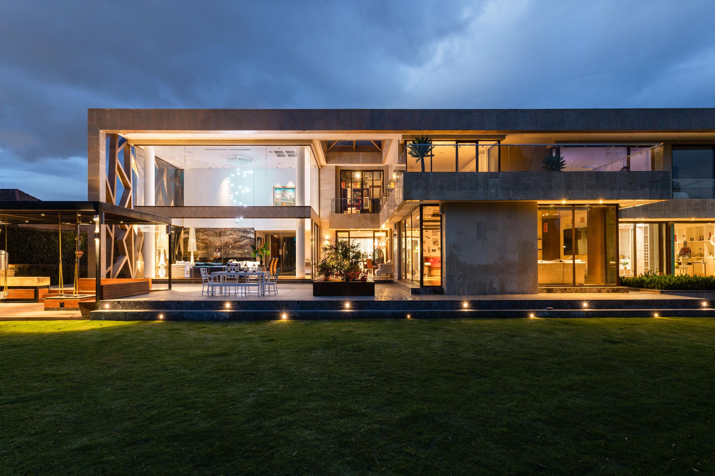 Moderne Villa in der Abenddämmerung mit warm beleuchteten Räumen